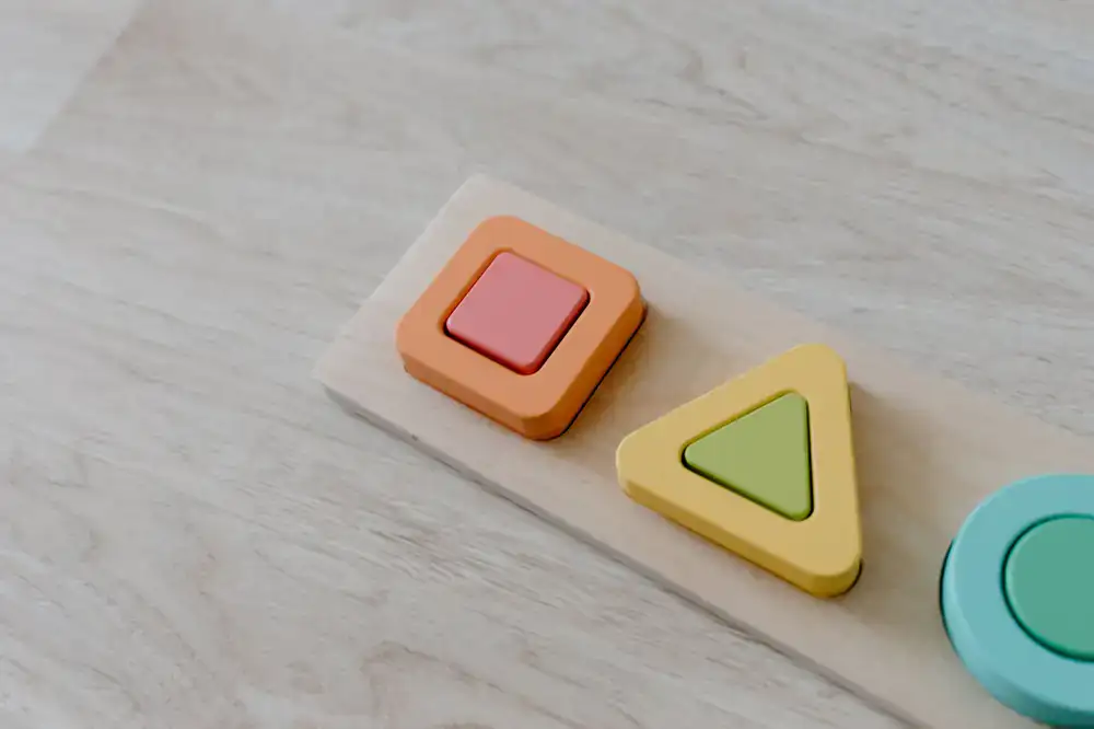 Wooden shape sorting tray with colorful pieces